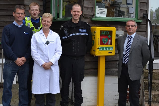 In 2013 a new defibrilator was installed in New Mills. Left to Right – Giles Wyatt (NMJFC U13’s Mngr), Adele Burton (Swizzels Matlow Security/Production Mngr), PCSO Will Brocket and Sgt Phil Booth (New Mills & Hayfield Safer Neighbourhood Team) and Mark Peacock (Cardiac Services Ltd). Photo Jason Chadwick