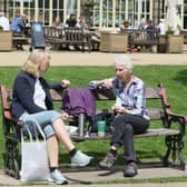 Two friends enjoying a catch up Buxton's Pavilion Gardens in the sun. Pic Jason Chadwick