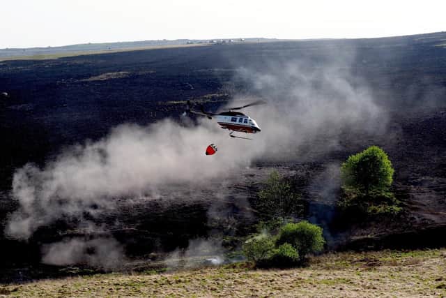 Fire on Big Moor: helicopter dropping water to damp down the fire.