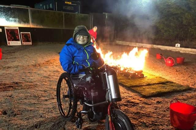 Peter Berriman lighting Buxton's first firewalk which raised £8,000 to help fund medical treatment which is not available on the NHS. Picture submitted