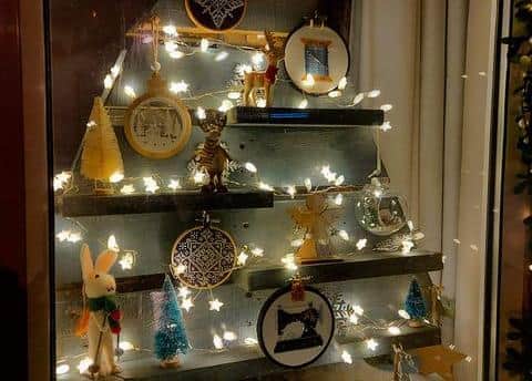 A jaw-dropping wooden Christmas tree complete with lights and shelves supporting tiny tree figurines