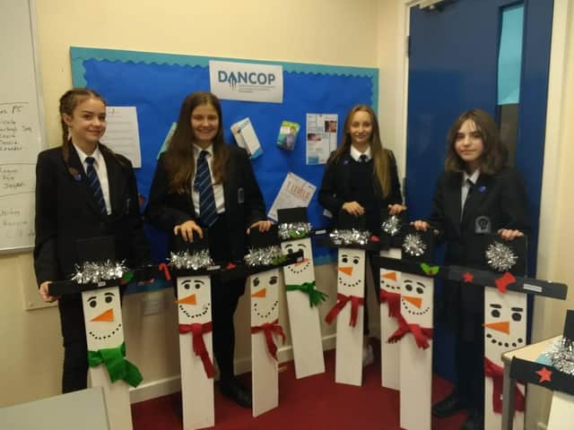Buxton Community School students with the snowmen they made