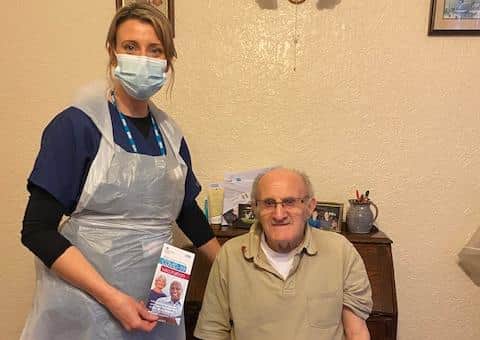 Advanced nurse practitioner Katie Cobain with newly-vaccinated Geoffrey Smith, 84
