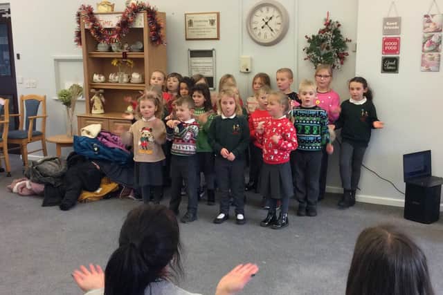 18 youngsters from Combs Infants brought Christmassy cheer to elderly members of the community. Photo Combs Infants