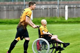 Jake Wright captain of New Mills Town FC with mascot Harry Budd the day before his operation to have his leg removed. Photo submitted