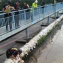Geoff Marshall is shown here on top of the wall - placing the sandbags