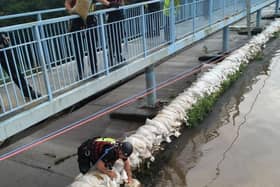 Geoff Marshall is shown here on top of the wall - placing the sandbags