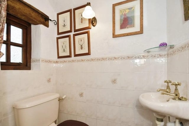 The downstairs cloakroom has a low flush WC, a wash hand basin and a stone flagged floor.