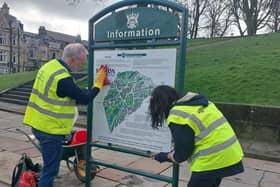 Two volunteers cleaning up the sign at the bottom of The Slopes. Pic Buxton Town Team