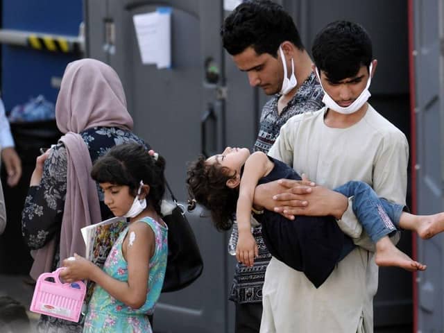 Afghan refugees are being evacuated from Kabul after the Taliban takeover. Photo by Olivier DOULIERY via Getty Images.