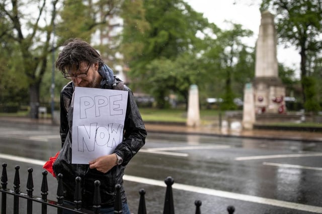 A man holds a sign relating to the lack of PPE equipment for frontline NHS staff during a minute's silence outside Lewisham Hospital (Photo: Dan Kitwood/Getty Images)