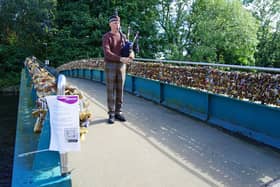 A lone piper walks across the bridge just before it was closed.