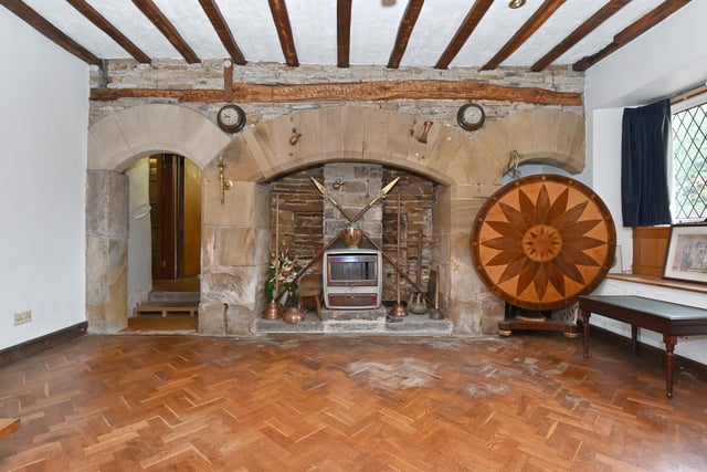 Decorative stone arches feature in both fire surround and doorway in this reception room with parquet flooring.