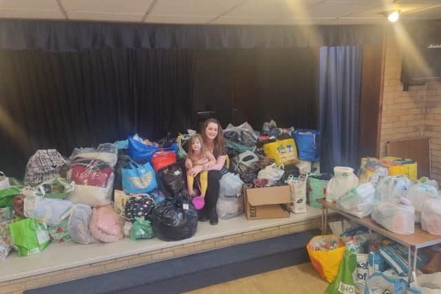 Kirsty Lownds and her daughter Willow at Dove Holes Village Hall with some of the donations which have been sent in to help Ukrainians who are fleeing their war torn country.