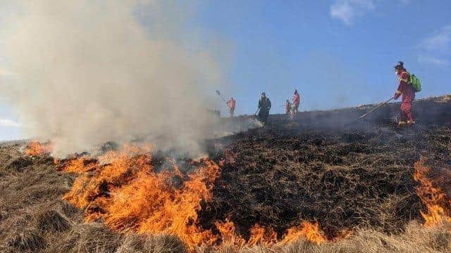 Firefighters tackling a moorland fire on Rushup Edge in April 2021.