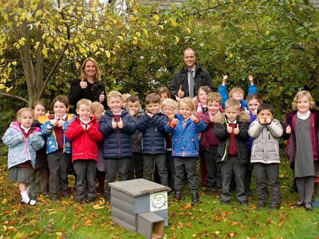 Taxal and Fernilee Primary school accepting hedgehog house from Biodiversity Whaley group.