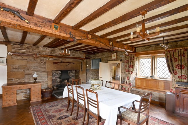 A characterful dining room with an inbuilt window seat and exposed stone walls to accompany the focal fireplace.