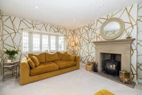 The "beautifully presented" sitting room has as a focal point of a multi fuel stove inset into a stone fireplace. There are two central heating radiators and recessed spot lights in the ceiling