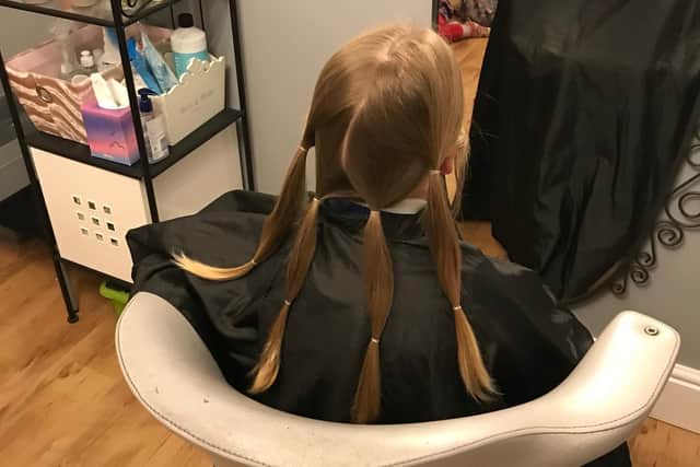 Six-year-old Jacob Hunt sitting in the chair ready to donate his hair to the Little Princess Trust - a charity which makes wigs for poorly children