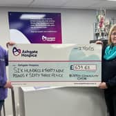 Matt Otty of Ashgate Hospice accepts donation from Teresa Oxley, Chairperson of Buxton Community Choir.