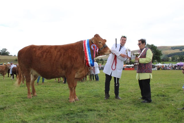 Matthew Clark  from Ringinglow receives the Beef Inter-breed Champion trophy from Hope Show president Petra Bridgestock.
