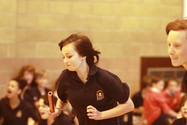 A girls relay race takes place in the sports hall at Buxton Community School.