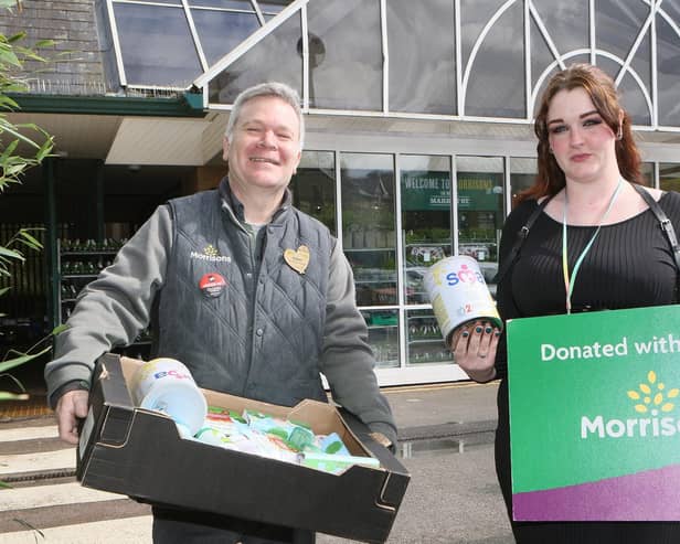 Morrisons Community Champion Rob Harrison hands over baby milk and other supplies to Kirsty Jackson of High Peak Baby Bank. Photo Jason Chadwick
