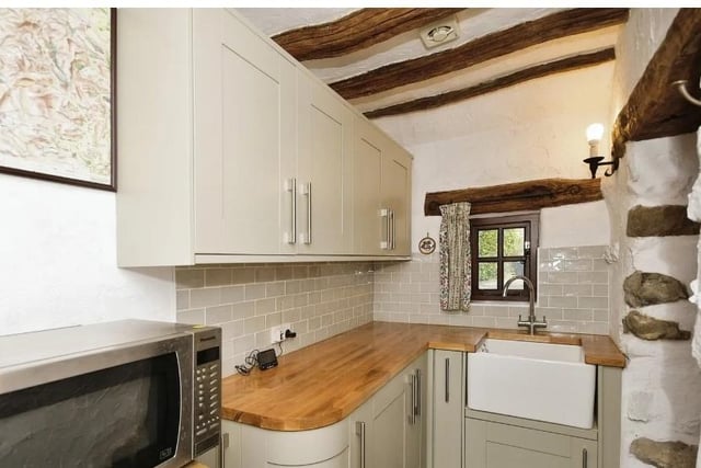 The utility room features a comprehensive range of kitchen units with wooden tops and an inset Belfast sink with a chrome mixer tap and an integrated washing machine. There are exposed beams to the ceiling and a wall mounted central heating radiator. Doors from the utility open into the cloakroom, the attached garage and an oak stable door opens onto the rear courtyard garden.