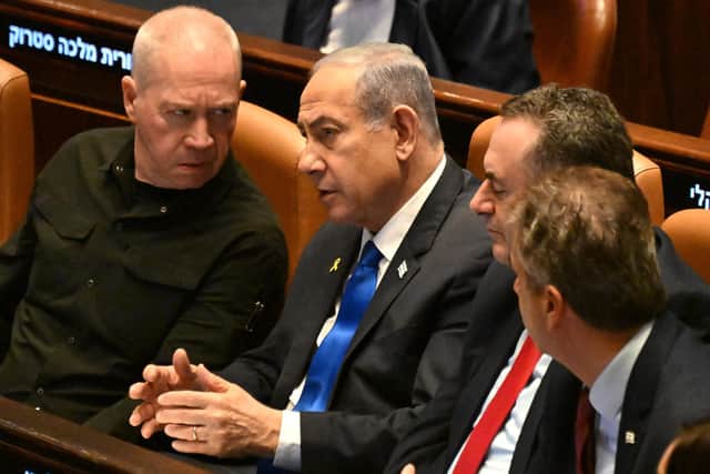 Israeli Prime Minister Benjamin Netanyahu (C) speaks to Defence Minister Yoav Gallant (L) at the opening of the 25th Parliament session in Jerusalem on October 28, 2024. (Photo by DEBBIE HILL/POOL/AFP via Getty Images)