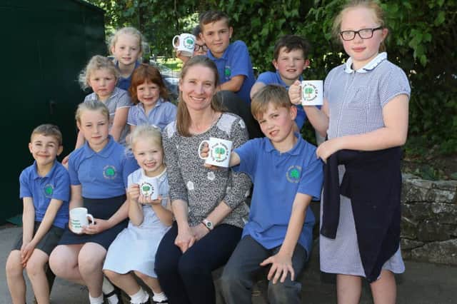 Peak Forest School 150th anniversary, current head teacher Ros Carter with some of the pupils and the commemorative mugs
