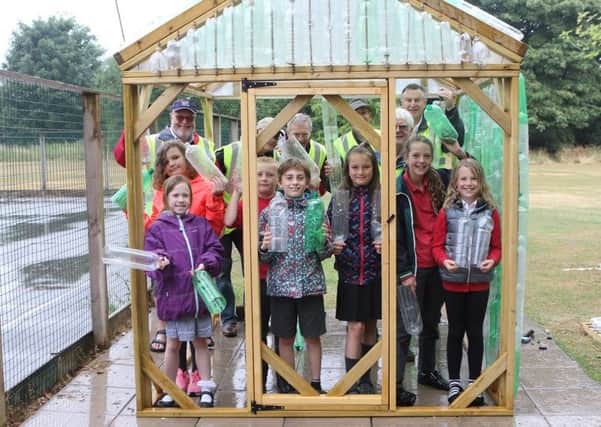 Buxton Junior School pupils and rotarians in the part-built greenhouse.