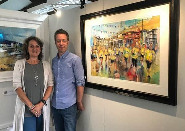 Chris Theyer stands with Rob Wilson who is supporting the Thomas Theyer Foundation by making prints of his new painting the Buxton Carnival Road Race which features Thomas