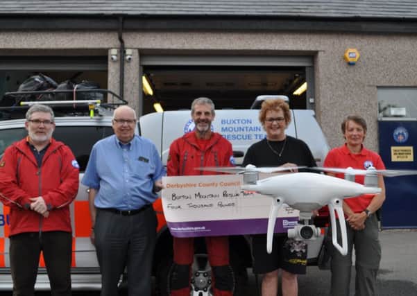 Derbyshire county councillor Jim Perkins presentis a cheque for Â£4,000 to Buxton Mountain Rescue Team.