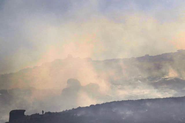 The figure of a firefighter stands out against a backdrop of burning moorland at the Roaches. Photo - Jason Chadwick
