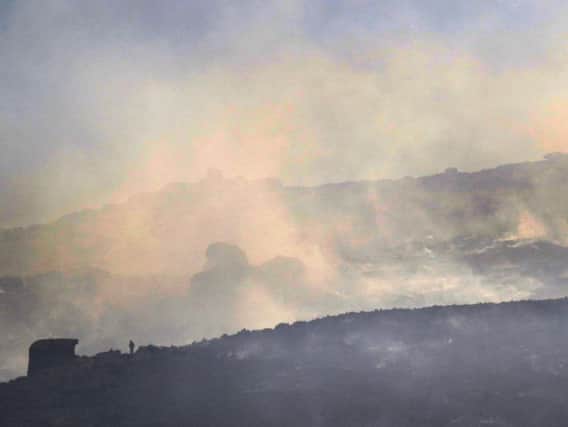 The figure of a firefighter stands out against a backdrop of burning moorland at the Roaches. Photo - Jason Chadwick