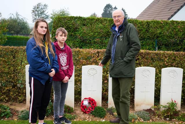 Sergeant Ralph Bagshaw's great-nephew, Clive Beddall, with his grandchildren, Daisy and Adam Beddall, laying a wreath on Ralph's grave. Photo: Martin Beddall.