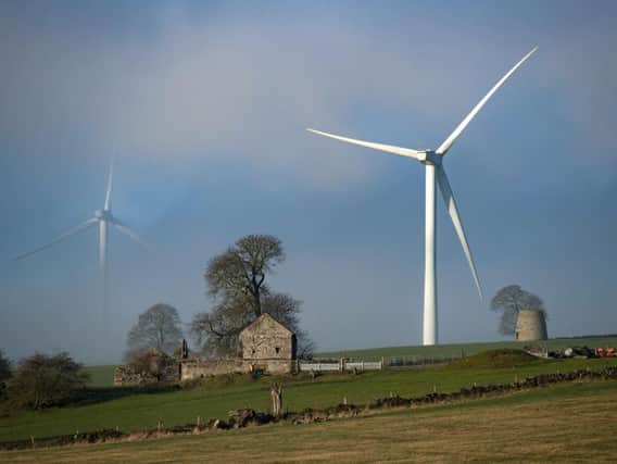 Wind turbines are shrouded in early morning mist near Carsington, Derbyshire.