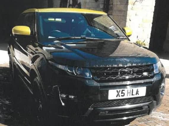 A stolen black Range Rover Evoque which has a yellow roof.