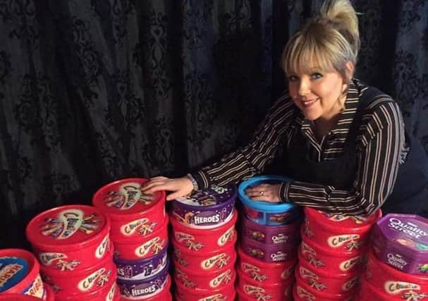 Nicky Land with some of the tubs of sweets collected previously.