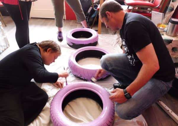 Service users at the Grapevine Wellbeing Centre working with Nestle and Derbyshire Wildlife trust for the Get Better With Nature campaign which saw them turning old tyres into planters