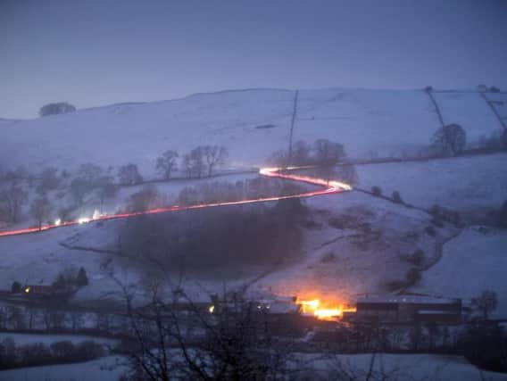 Cars making their way up and down a hill near Crowdecote in the Peak District after snowfall on Friday evening. Photo: Rod Kirkpatrick / F Stop Press.