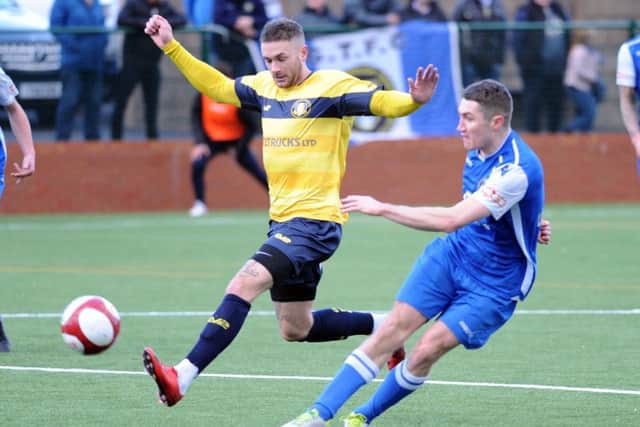 Buxton v Gainsborough Trinity. 
Joe McGee sends the ball forward under pressure from Ashley Worsfold.