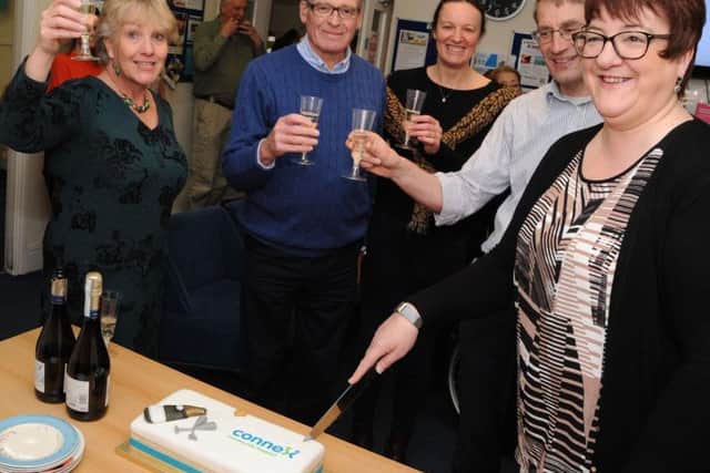 The Connex Community Support chairman of trustees, Tina Sullivan, right, cuts the cake to continue celebrations of the re-branding of the community charity based on Buxton Market during a special event on Friday. Also pictured are from left, Gill Geddes, David Brindley, Helen Hazelhurst and Robert Shaw. Photo: Anne Shelley.