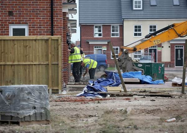 Construction workers build new houses on a housing development. Photo by Christopher Furlong/Getty Images.