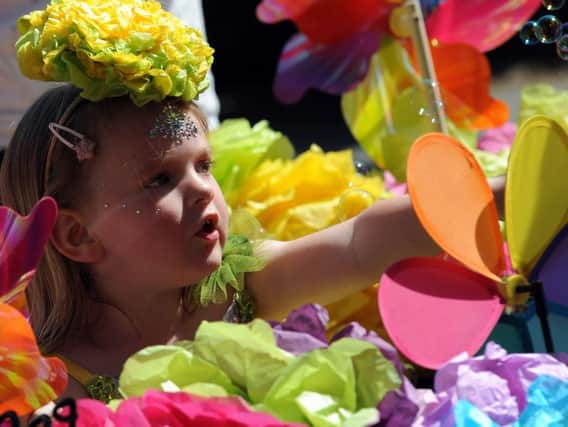 A youngster peaks through a floral float.