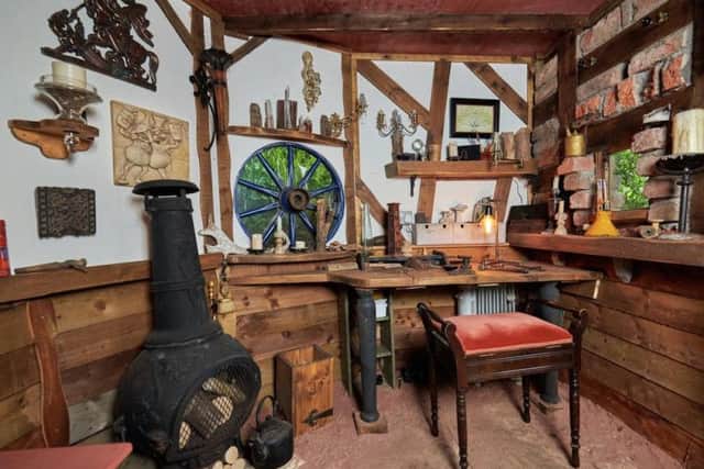 Compete with log burner and armchair, Chris uses his shed to work on his hobby of making armour and chain-mail.
