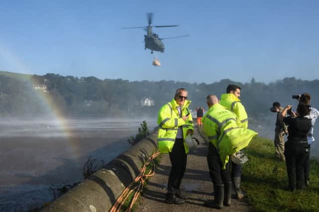 A Chinook helicopter creates a rainbow in the spray as it prepares to drop sandbags onto the dam wall at Toddbrook reservoir following a severe structural failure after heavy rain, on August 02, 2019 in Whaley Bridge.  (Photo by Leon Neal/Getty Images)