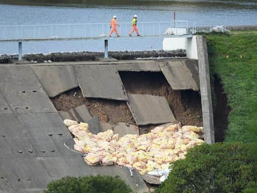 Members of the emergency services check the positioning of bags of aggregate after they were dropped onto the dam wall at Toddbrook Reservoir. Photo by Leon Neal/Getty Images.