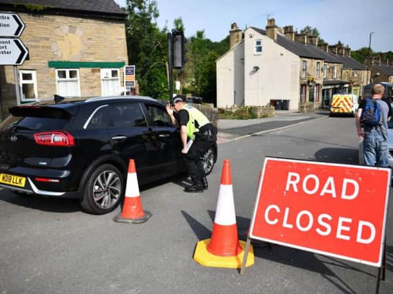 A police officer helps maintain a cordon in Whaley Bridge. Photo by Leon Neal/Getty Images.