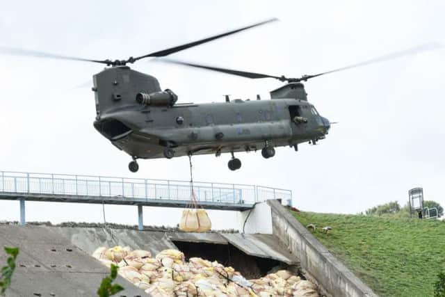 A Chinook helicopter drops sandbags onto the dam wall at Toddbrook Reservoir. Photo: Leon Neal/Getty Images.